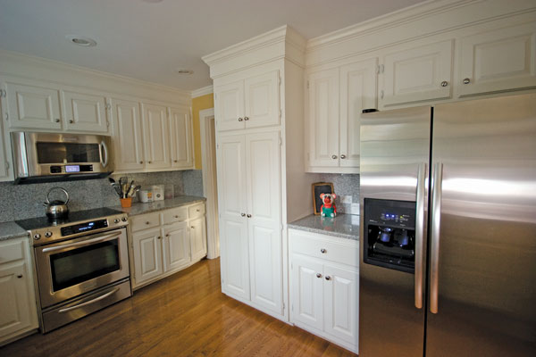 
AFTER. With its original wood cabinets, the kitchen was updated with energy star appliances and a built-in recycling center.
